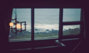 a view of the ocean from a window at La Beaute Jeju Pension in Seogwipo