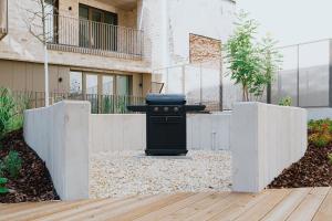 a barbecue grill in a courtyard with a building at Studio 202 in Brno