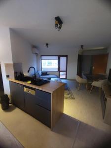 a kitchen with a counter and a living room at Апартамент Skyline in Yambol
