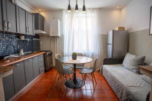 a kitchen and living room with a table and a couch at Barrique 13 - Breakfast at Restaurant & Minibar - Old Town in Braşov