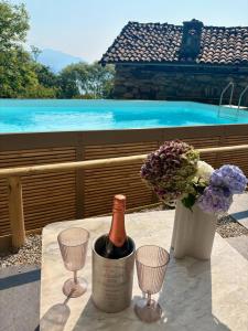 a bottle of wine sitting on a table with two wine glasses at Raggio di Sole Villa in Oggebbio