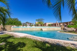 a swimming pool in a yard with palm trees at Masseria Marchese by Perle di Puglia in Montesano Salentino