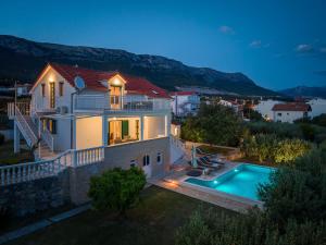 a house with a swimming pool in the backyard at Holiday Home Nevera in Kaštela