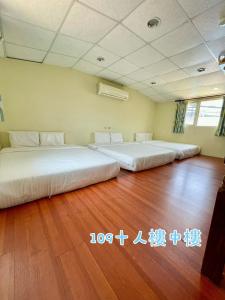 two beds in a room with wood floors at 蒲Going旅宿 in Xiaoliuqiu
