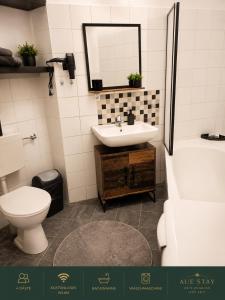 a bathroom with a sink and a toilet and a mirror at Aue Stay in Kassel