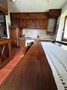 a kitchen with a large wooden table in the middle at Maison Gerbore in La Salle