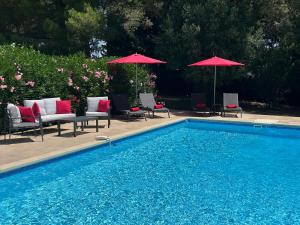 a swimming pool with chairs and umbrellas next to at The yurt at Gites 474 in Sallèles-dʼAude