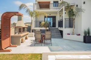 a patio with a table and chairs in front of a house at Eagle's Nest - Adjoining Villas! in Tsilivi