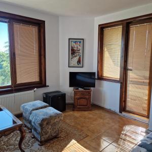 a living room with a tv and a chair at Guest House Nash Dom in Kavarna