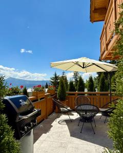 a grill and an umbrella on a patio at Villa Bergbliss in Bukovel