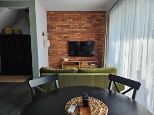 a living room with a couch and a tv and a table at Wypoczynek nad morzem Uzdrowiskowa 115 in Przewłoka