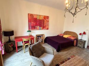 a bedroom with a bed and a table and a chair at La Vigneronne in Maureilhan-et-Raméjan