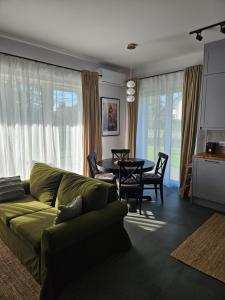 a living room with a green couch and a table at Wypoczynek nad morzem Uzdrowiskowa 115 in Przewłoka