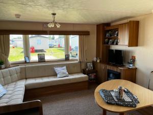 a living room with a couch and a table at California cliffs caravan in Great Yarmouth