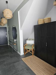 a room with a black cabinet and a mirror at Wypoczynek nad morzem Uzdrowiskowa 115 in Przewłoka
