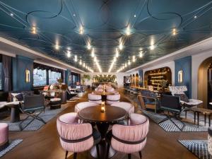 a lobby with a bar with pink chairs and tables at Mercure Tokyo Hibiya in Tokyo