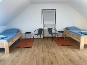 two beds in a room with chairs and a table at WORK & Rest Monteurzimmer in Batzhausen