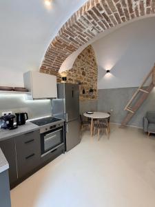a kitchen with a stove and a table in a room at Encanto Griego in Chios
