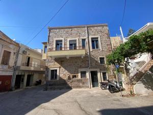 a stone building with a motorcycle parked in front of it at Encanto Griego in Chios