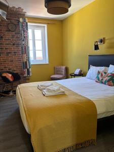 a bedroom with a large bed with yellow walls at L'Aiguille Creuse in Étretat