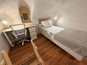 a bedroom with a bed with a desk and a chair at Encanto Griego in Chios