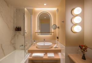 a bathroom with a sink and a shower and a mirror at Hôtel Burdigala by Inwood Hotels in Bordeaux