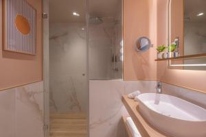 a bathroom with a sink and a shower at Hôtel Burdigala by Inwood Hotels in Bordeaux