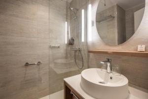 a bathroom with a sink and a shower with a mirror at Hôtel Arcanse by Inwood Hotels in Arcachon