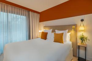 a bedroom with a large bed and a large window at Hôtel Arcanse by Inwood Hotels in Arcachon +44 photos