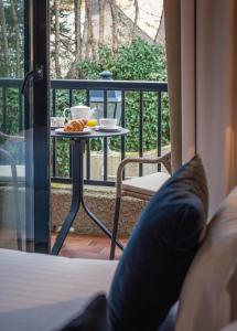a bed and a table with a breakfast on a balcony at Hôtel Arcanse by Inwood Hotels in Arcachon