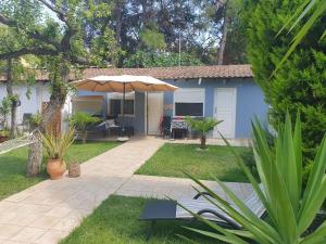 a blue house with an umbrella in the yard at Hotel Villa Anais in Prinos