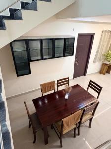 a dining room with a wooden table and chairs at Veechi Retreat in Secunderabad