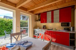 a kitchen with red cabinets and a table at Heideröschen Park Heideröschen 5c in Zingst
