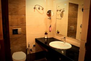 a bathroom with a sink and a toilet at Sapphire Hotel & Convention Centre in Baddi +15 photos