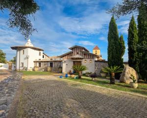 a house with a church and a driveway at Santo Re Olive Retreat in Petrizzi