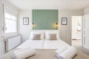 a white bedroom with two beds and a window at Schiller in Wandlitz