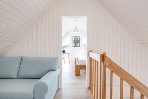 a living room with a blue couch and a staircase at Schiller in Wandlitz