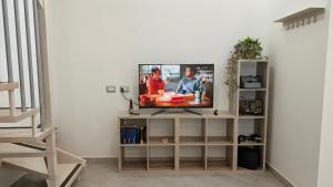 a television sitting on a shelf in a living room at Alloggio Turistico Francy House in Lido dei Pini