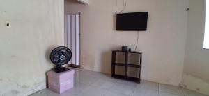 a room with a fan and a television on a wall at CasaLima in Bragança