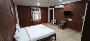 a bedroom with a bed and a window and a tv at Hotel Casa viora at swimming pool in Calangute