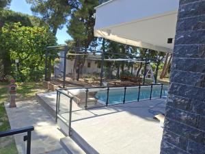 a swimming pool with a glass enclosure on a house at Grey Pearl Apartments in Nea Kallikrateia