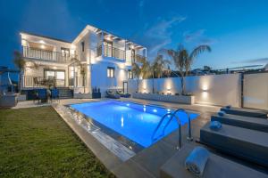 a villa with a swimming pool in front of a house at Eagle's Nest - Adjoining Villas! in Tsilivi