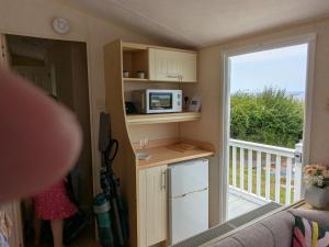 a tiny house with a kitchen and a balcony at Ocean View in Aberaeron