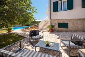a patio with chairs and a table next to a house at Holiday Home Nevera in Kaštela