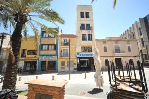 a palm tree and a statue in the middle of a street at casa Bayer in Benicàssim