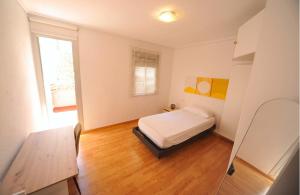 a bedroom with a bed and a table and a window at casa Bayer in Benicàssim