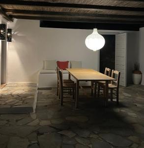 a dining room with a wooden table and chairs at Salt & Sun Terrace Seafront in Agioi Apostoli