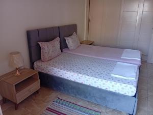 a bed with a blue headboard and a night stand at Paradise Rose in Sfax