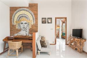 a living room with a mural of a head on a wall at Dijero at Umah Bali in Ubud