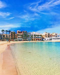 a view of a beach with buildings in the water at Ayla Studio House I Seaside Cosy and Modern in Birżebbuġa